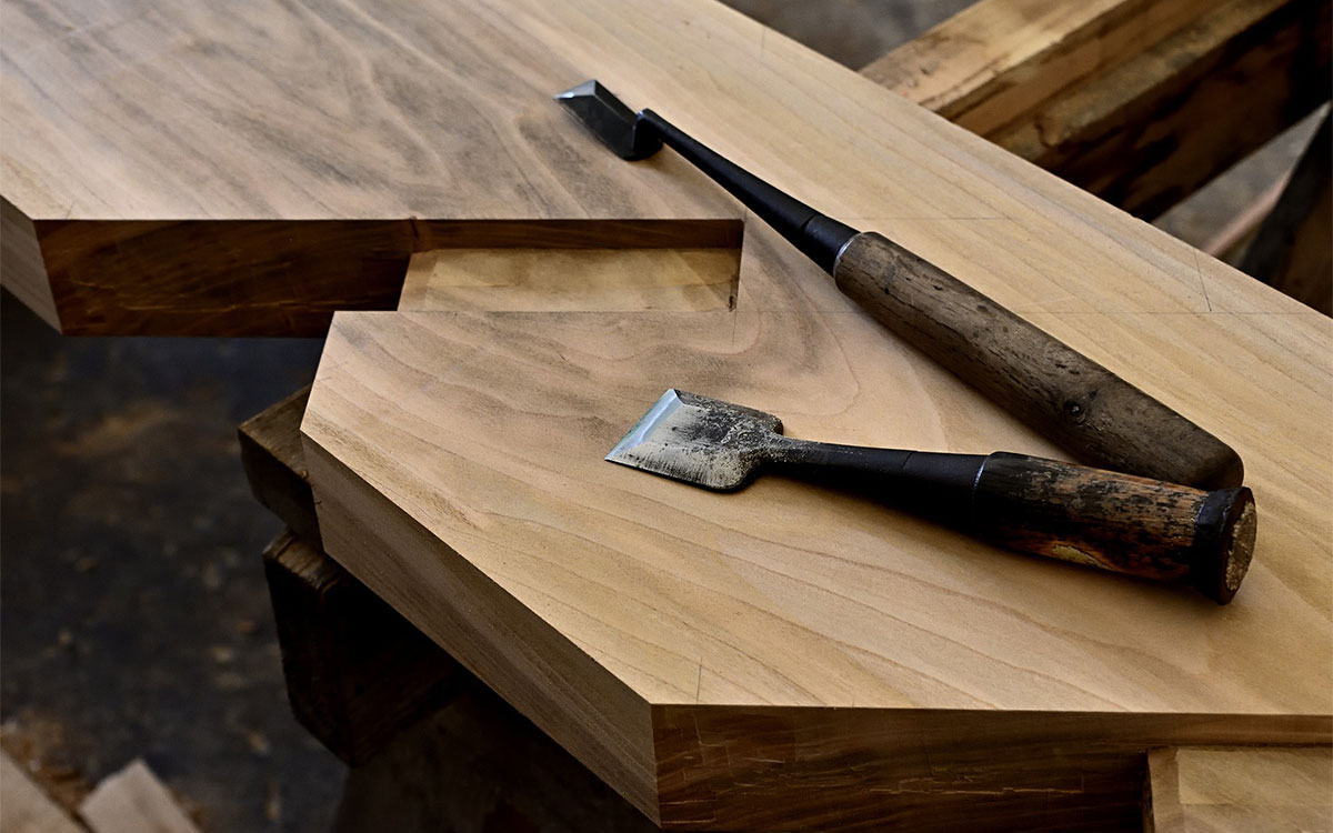 Meisterstücke aus verschiedenen Handwerksbranchen: Tischler-Werkzeuge liegen auf verarbeiteten Holz