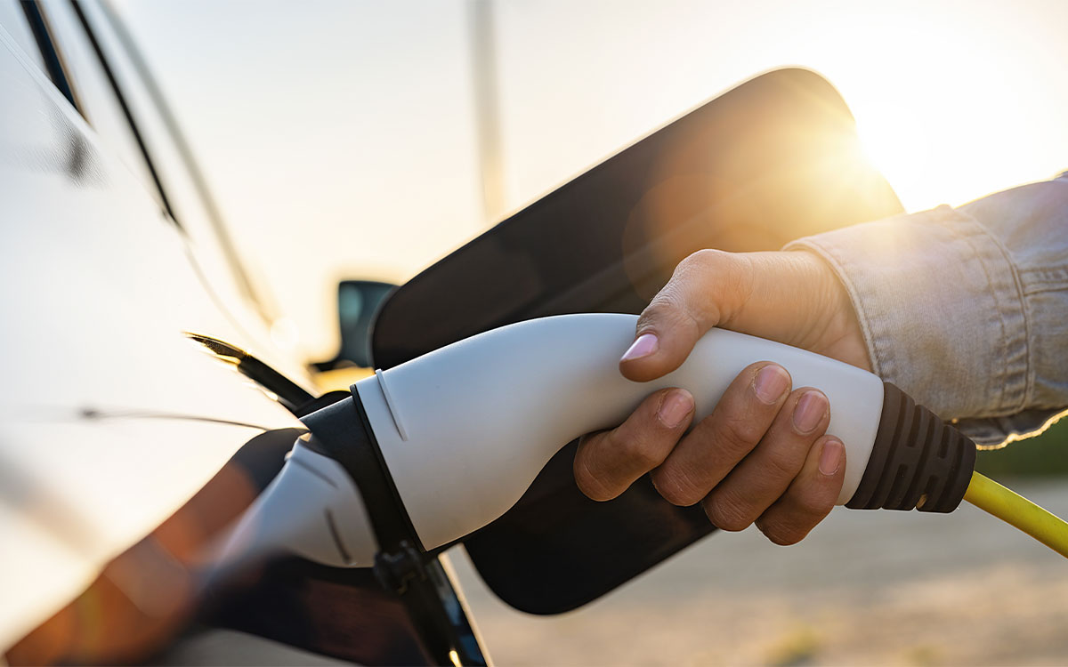 Nachhaltigkeit Handwerk Elektrotechniker: Person befüllt Elektrisches Auto mit Strom, Innovative Technologien für eine grüne Zukunft