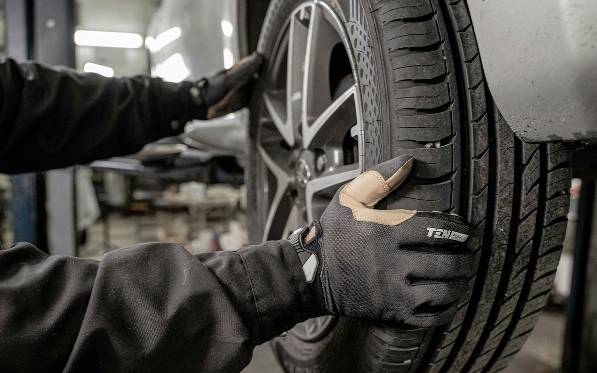 Zeitmanagement Kfz-Technikermeister: Person wechselt den Reifen eines Autos
