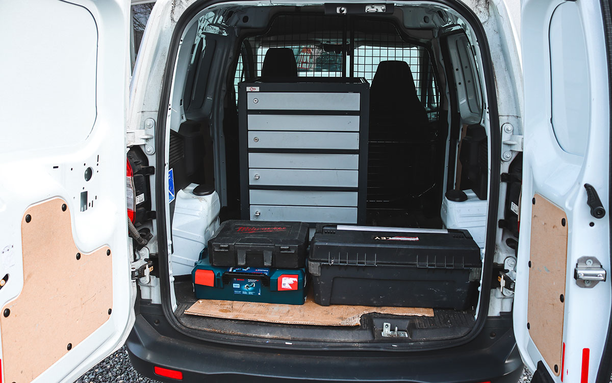 Blick in den ausgerüsteten Einsatzwagen eines Schlüsseldienstes mit Werkzeugkoffern und Schubladenschrank – bereit für den mobilen Einsatz vor Ort.